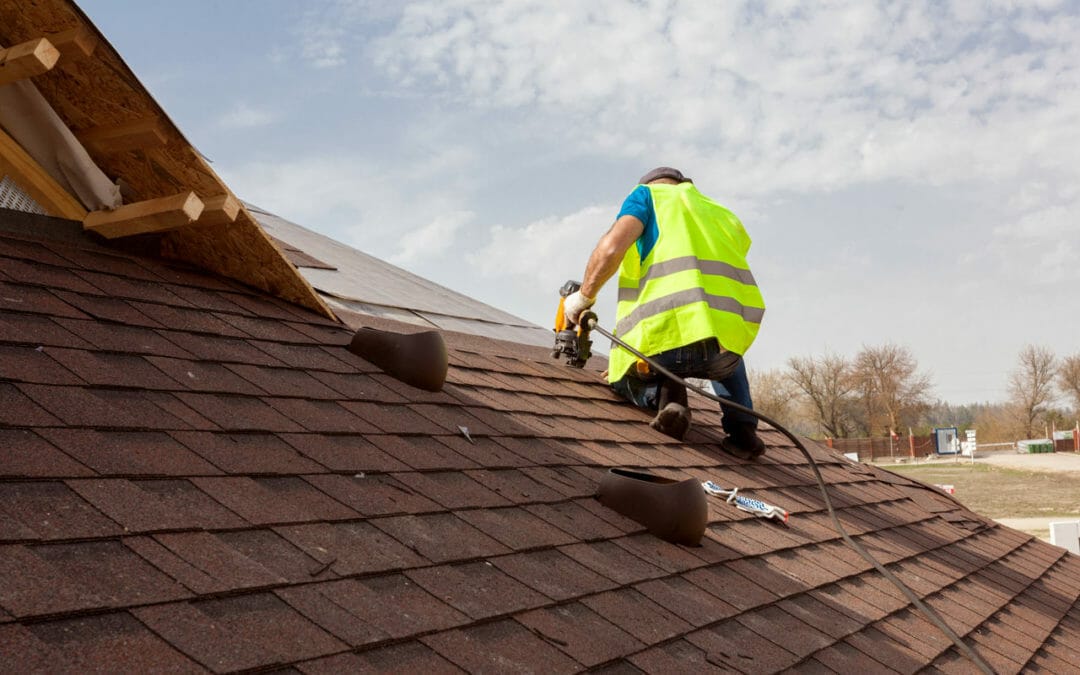Roofing contractor installing an asphalt shingle